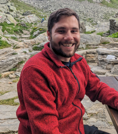 Raffael Di Iorio sitting on a bench in the Swiss Alps.